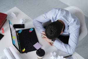 homme endormi sur son ordinateur au travail